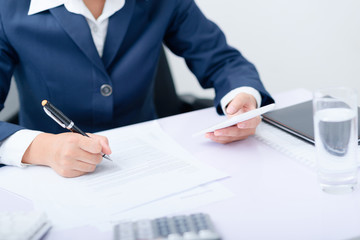 Businesswoman using smart phone work at desk.