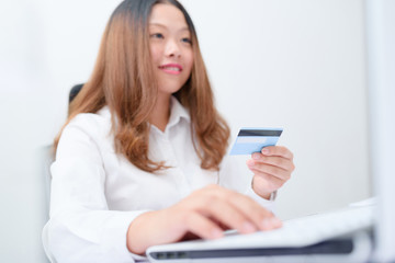 Fototapeta na wymiar Young woman using credit card paying on laptop.