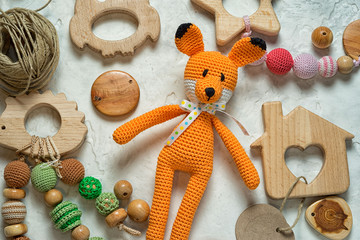 amigurumi fox toy laying among mess wooden toys and beads