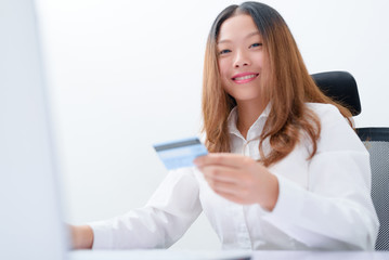 Young woman using credit card paying on laptop.