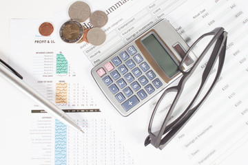 Business report  with calculator, glasses and pen.