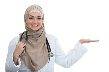 Closeup portrait of friendly, smiling confident Muslim female doctor pointing arm.
