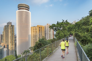 Urban sports - couple jogging for fitness in Hong Kong city with skyscraper background