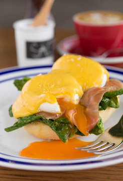 Eggs benedict and fresh salmon serves on a lightly toasted muffin served with hollandaise sauce and a coffee.