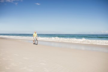 Smiling senior man riding bike