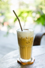 Glass of ice cappuccino on wooden table