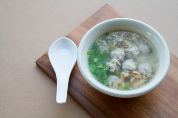 Rice boiled with pork, garlic and coriander bowl on wooden and spoon.