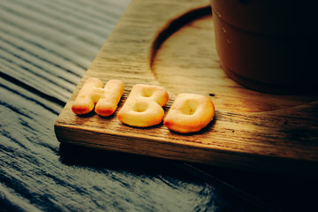 iced coffee and biscuit alphabet spell HBD with rice field backg