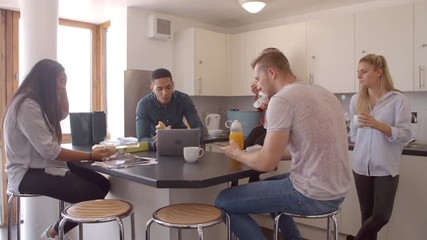 Students Relaxing In Kitchen Of Shared Accommodation