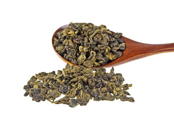 Dry green tea leaves in wooden spoon on white background