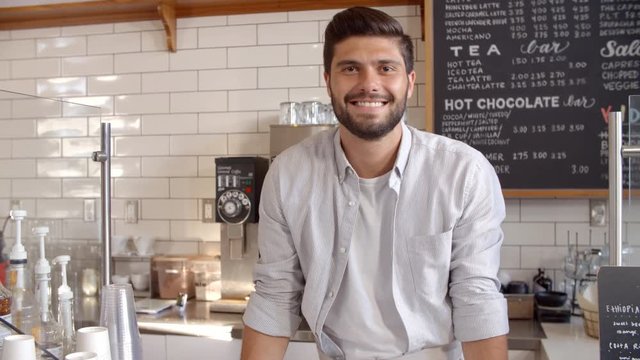 Business owner standing behind the counter at a coffee shop