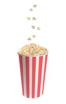 Popcorn falling into a classic striped bucket isolated on white background