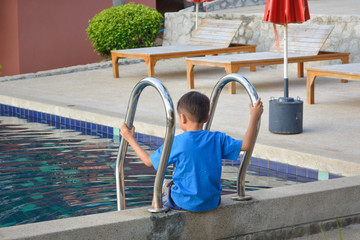 Naklejka premium A boy site on stairs pool