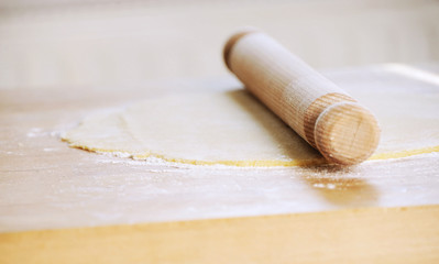 Baking gingerbreads on a wooden background. Christmas cake making with rolling pin and flour. Hand made cake at home