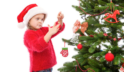 Little girl hanging Christmas decoration on the tree