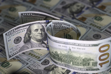 Three hundred us dollar bills standing on hundred us dollar banknotes background. Two banknotes turned by  Benjamin Franklin on the obverse, one by reverse with an image of Independence Hall.