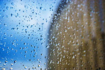 Abstract background. Drops of water on the window. High-rise buildings.