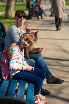 Girl on roller skates sitting on bench