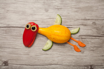 Flying duck made of vegetables on wooden background