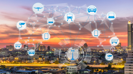 Internet of Things and Smart city concept. Smart things icons mesh on city traffic at twilight background.