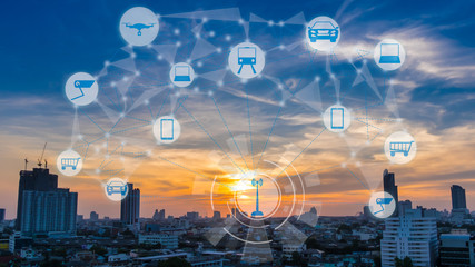 Internet of Things and Smart city concept. Smart things icons mesh on city traffic at twilight background.
