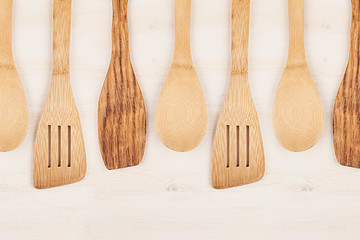 Design concept of mockup of empty wood beige spoons on white wood background.  Copy space. Top view.