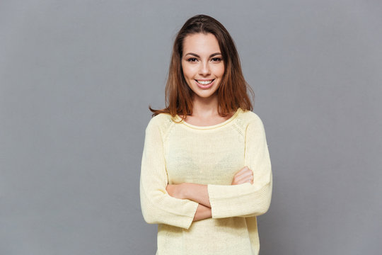 Cheerful Smiling Woman In Sweater Standing With Arms Folded