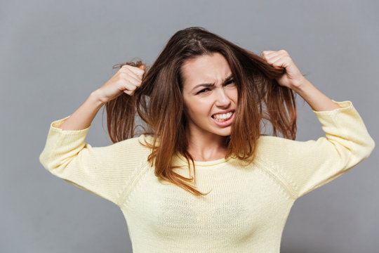 Portrait of a fustrated angry woman pulling her hair out