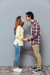 Portrait of a young interracial couple holding hands and kissing