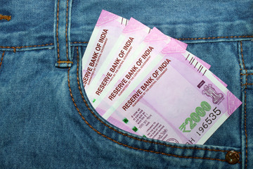 Obraz premium New 2000 rupee notes in an Indian mans jean front pocket.