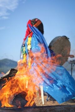 shaman conducts the ceremony near the fire. View through the fire. Authentic photos.