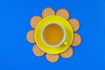 Funny arrangement  cup of tea on blue wooden table with sweet co