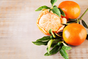 Ripe Mandarin Fruit  and Green Leaves on Old Rustic Wooden Board