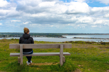 Woman sitting on a wooden bench in Bournemouth, England