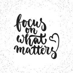 Focus on what matters - hand drawn lettering phrase isolated on the white grunge background. Fun brush ink inscription for photo overlays, greeting card or t-shirt print, poster design