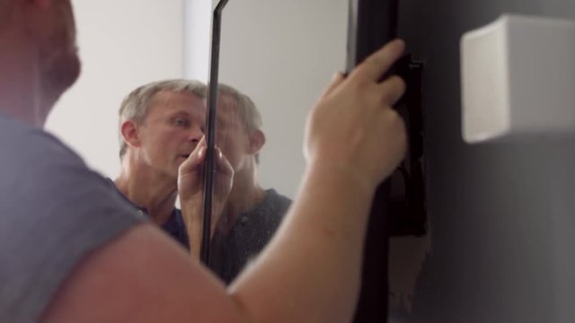 Two Men Fitting Flat Screen Television To Wall Shot On R3D