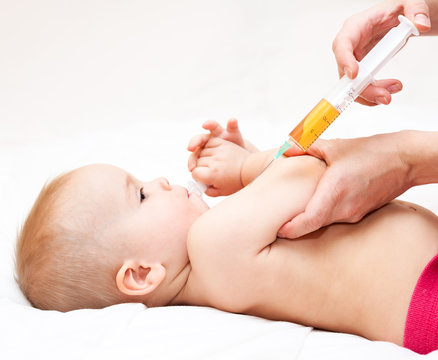 Close-up Shot Of Pediatrician Ready To Give An Intramuscular Injection Of A Vaccine To A Baby Girl