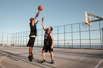 Portrait of two players with basketball at the playground