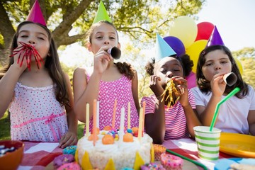 Children breathing out in a birthday trumpets 