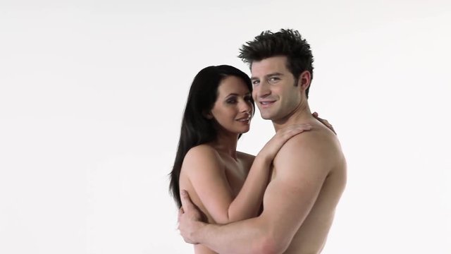 Nude couple kissing and smiling at camera