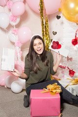 Young pretty woman opening gifts