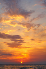 Beautiful sunset in tropical sea. Sun through clouds