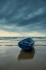 Small blue rowboat on beach