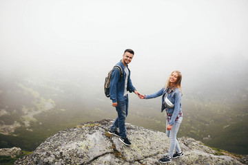 incredibly beautiful and young couple standing on the precipice
