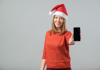 Young  woman with Santa hat showing smartphone