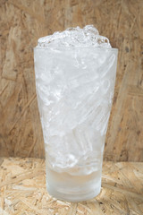 glass with ice on the wooden bar