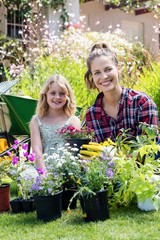 Portrait of mother and daughter gardening together in garden