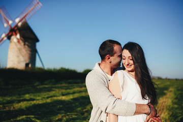 loving and beautiful couple standing together near a large mill