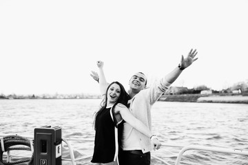 happy and young couple are floating on a yacht
