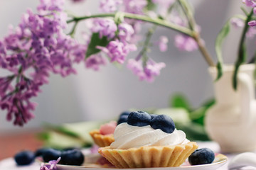cupcakes with blueberries on the table against the background of lilac